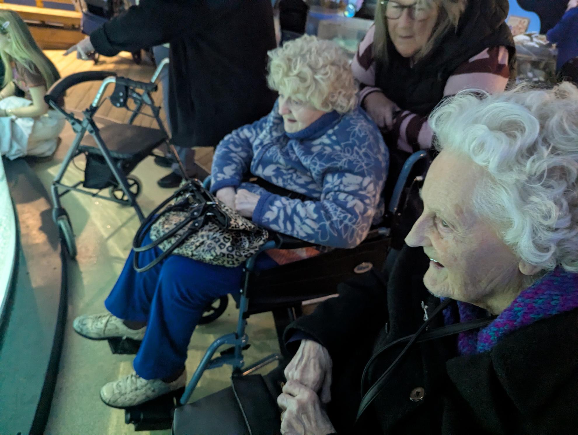 people smiling looking at a marine enclosure 