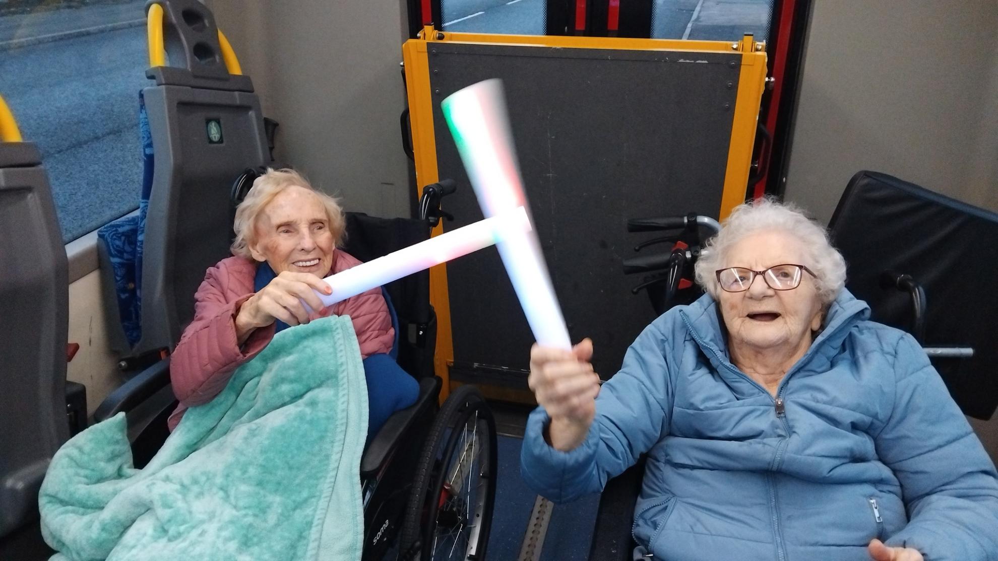 photo of people sat smiling with glow sticks