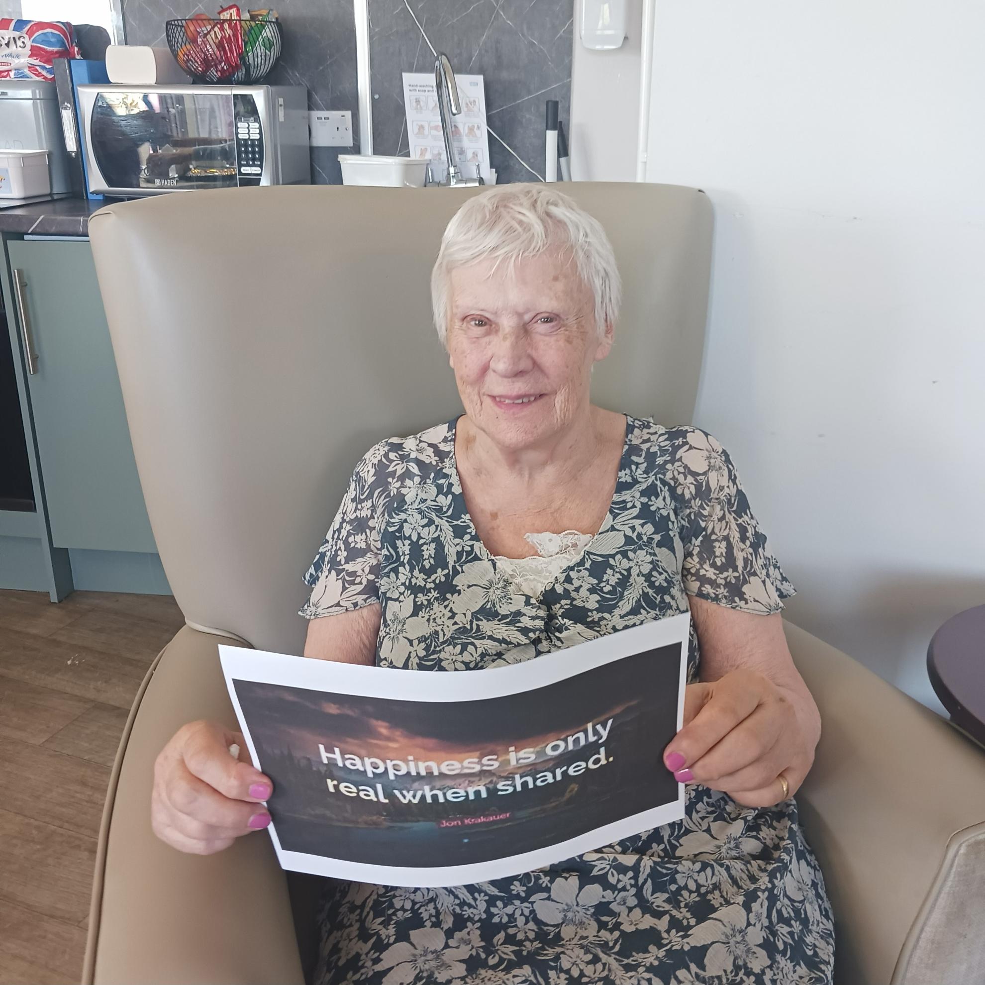 Photo of Denise holding quotes about happiness