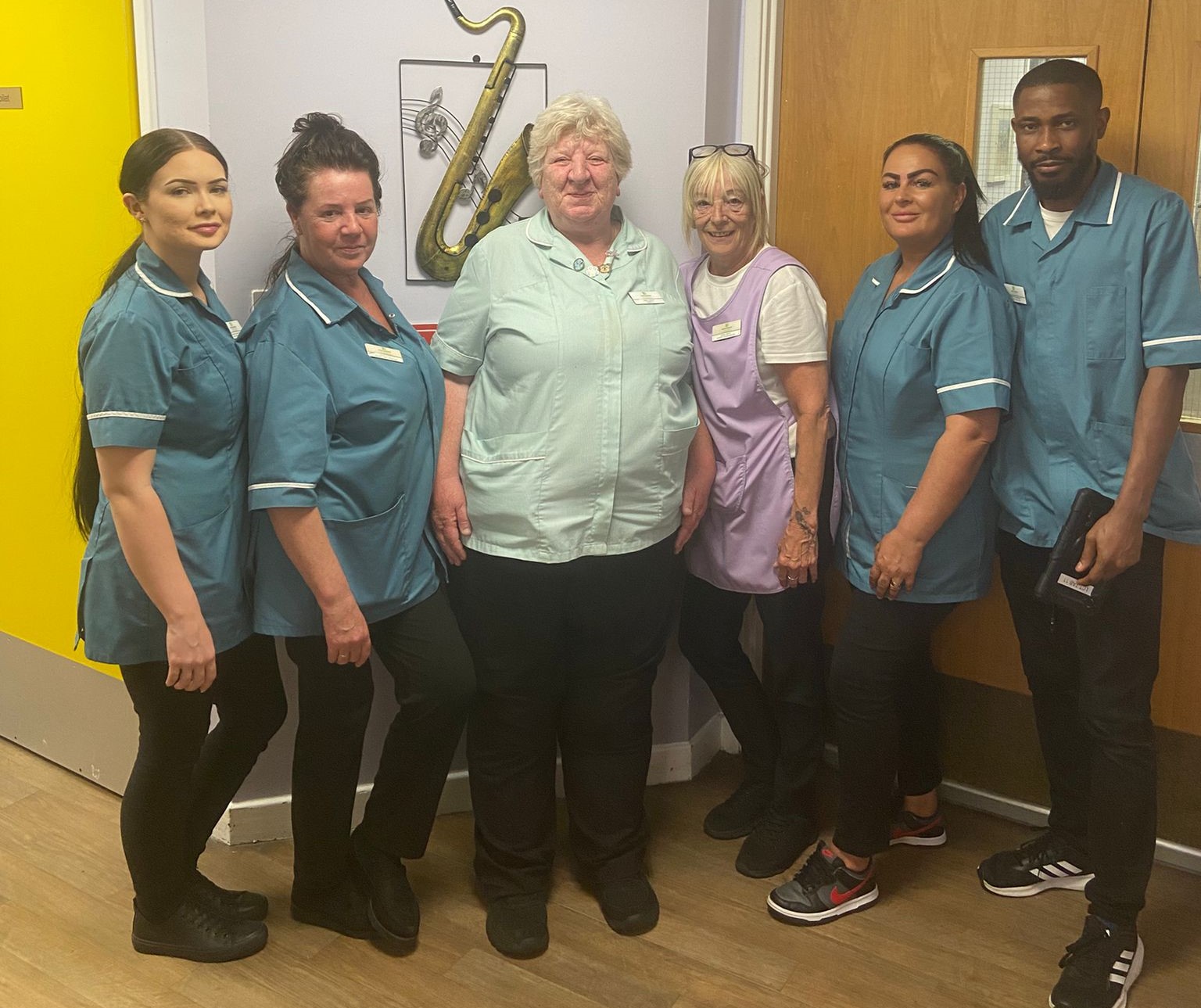 Gwen smiling proudly with her colleagues