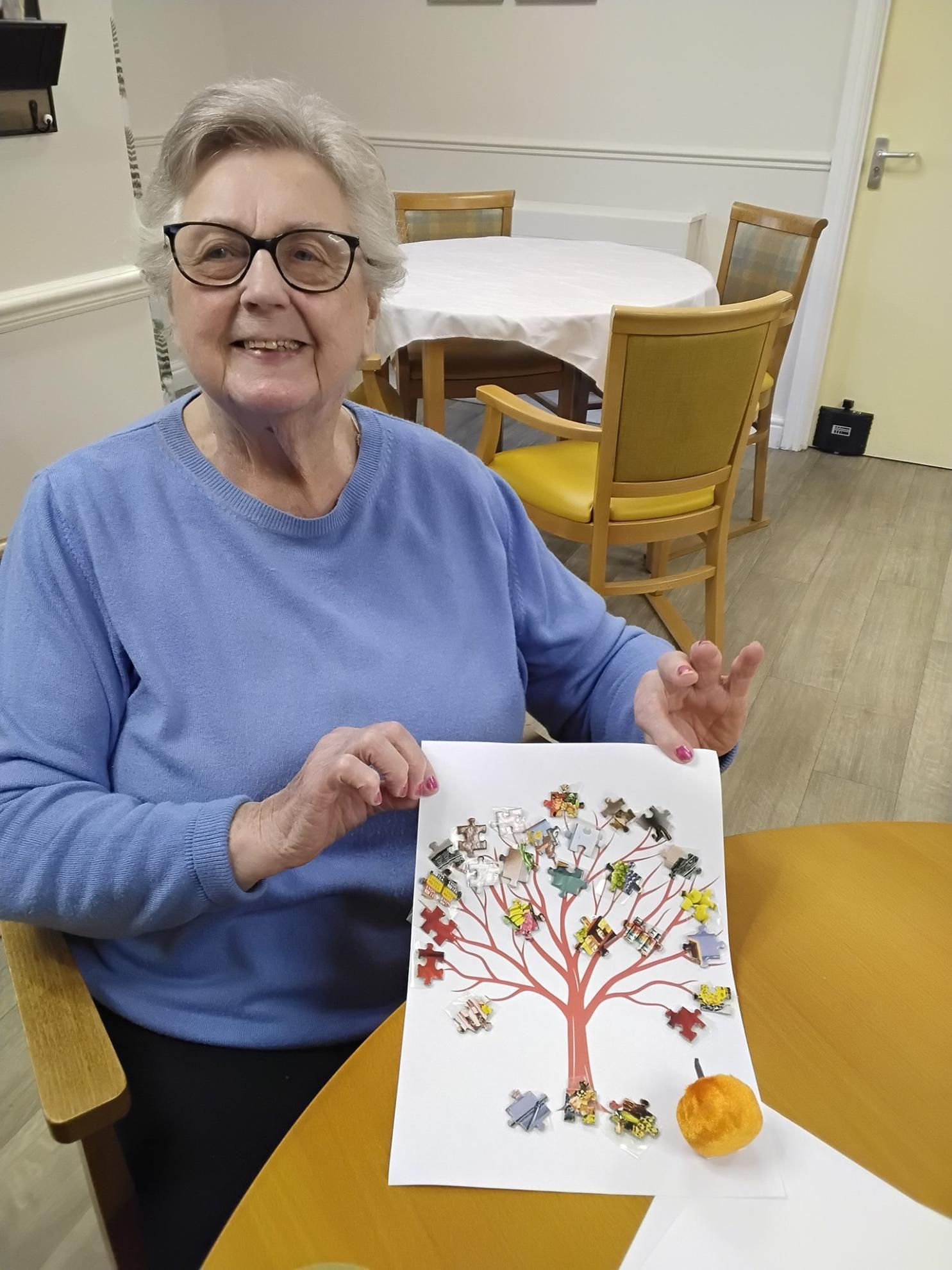 Photo of Robena proudly holding her jigsaw tree