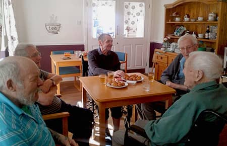 Residents enjoying their regular gentlemen's club with drinks and snacks.