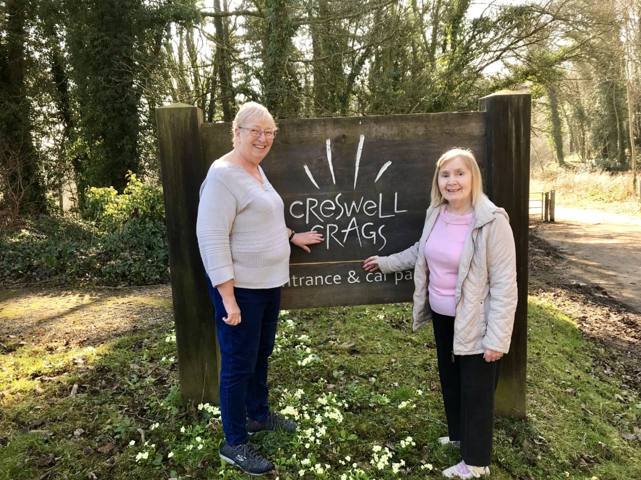 Residents outside Creswell Crags sign.