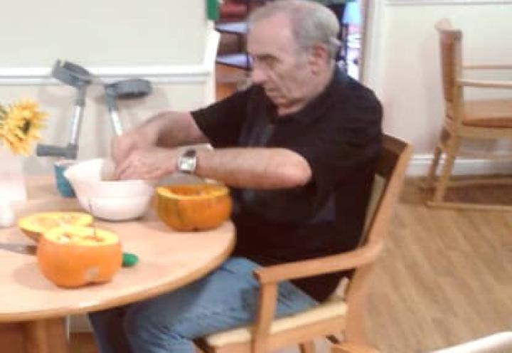 Resident scopping the seeds out of his pumpkin. 