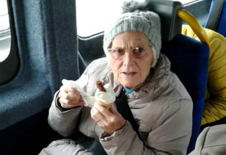 resident enjoying her icecream in the minibus. 