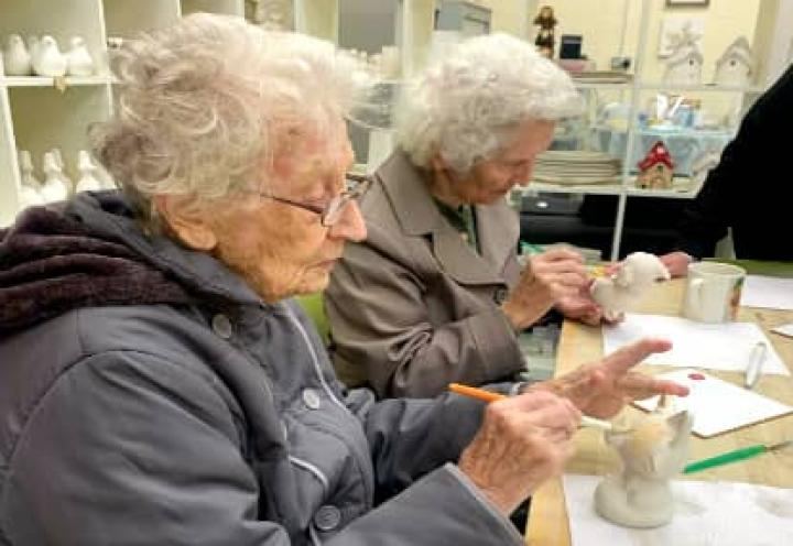 residents painting their pottery. 