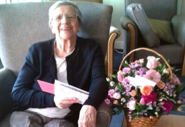 resident with mothers day card and flowers.