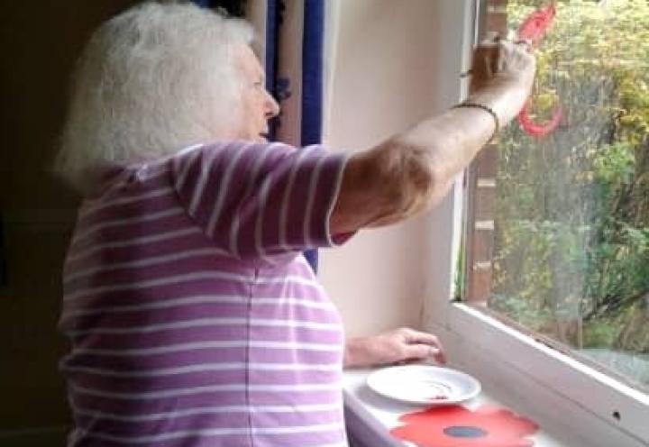 resident Dora painting poppies on the window. 