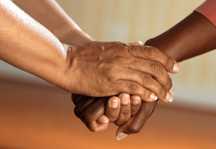 Picture of carer holding a patient's hand