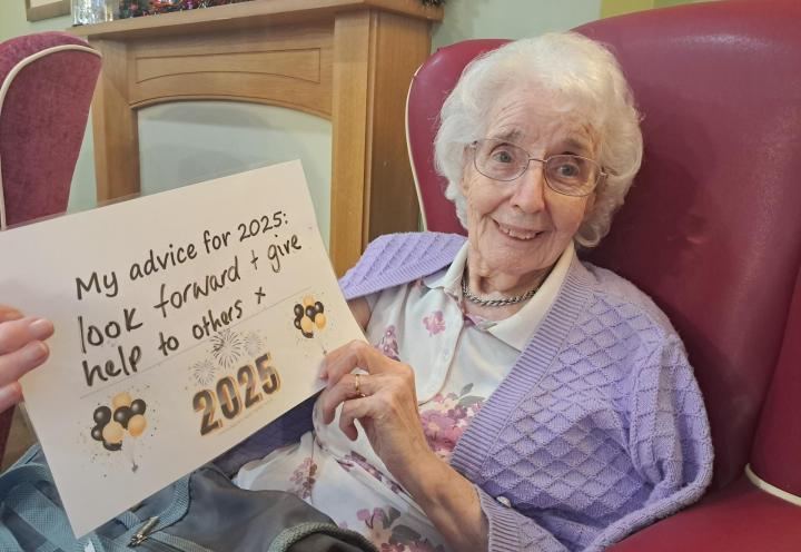 Photo of a lady holding up a sign for 2025