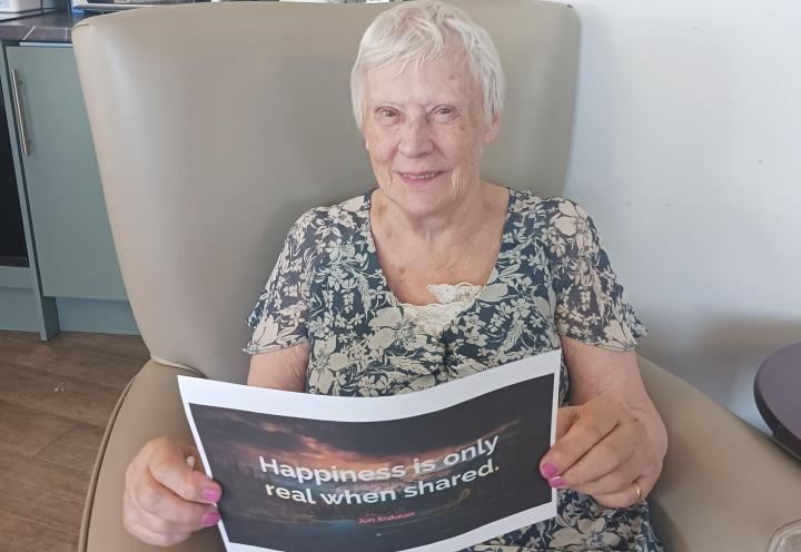 Photo of Denise holding happiness quote