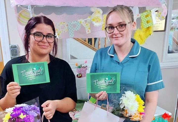 Photo of 2 colleagues with flowers
