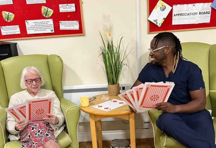 photo of 2 people playing XL cards sat down