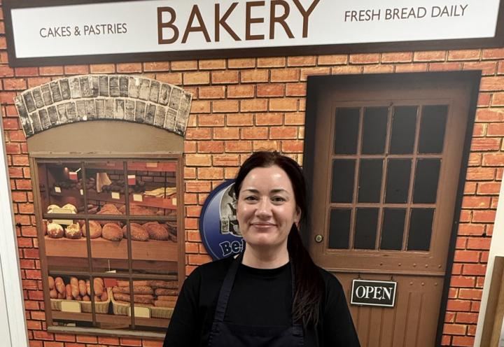 Stacy smiling with Bakery backdrop